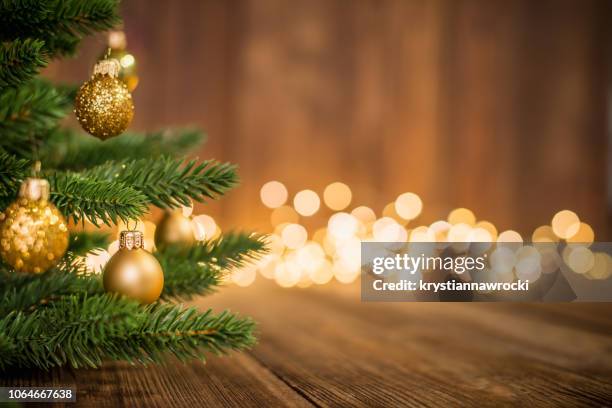 fir tree decorated with christmas balls on rustic wood and sparkles light background - christmas tree branch stock pictures, royalty-free photos & images