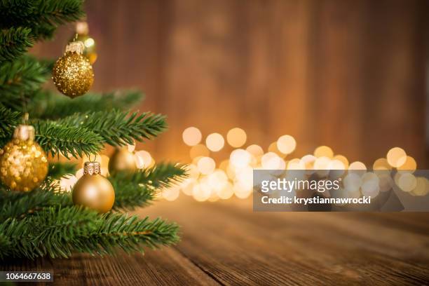 pinheiro decorado com bolas de natal em madeira rústica e brilhos backgorund luz - gold decoration - fotografias e filmes do acervo