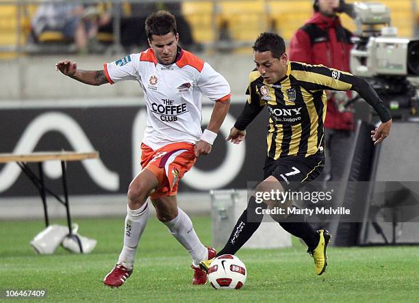 Leo Bertos of the Phoenix dribbles the ball with Milan Bowles of the Roar in defense during the round 12 A-League match between the Wellington...