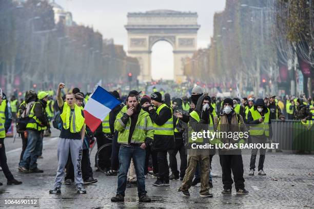 Yellow vests protestors demonstrate near the Arc de Triomphe on the Champs Elysees in Paris, on November 24, 2018 during a protest against rising oil...