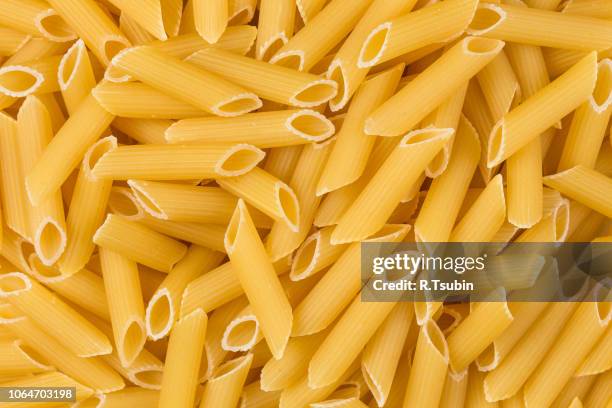 closeup photo of uncooked italian penne pasta background - penne imagens e fotografias de stock