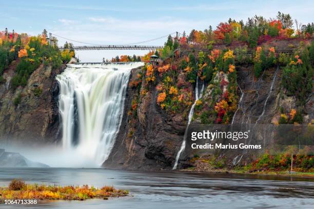 montmorency falls and bridge in autumn with colorful trees - ケベック州 ストックフォトと画像