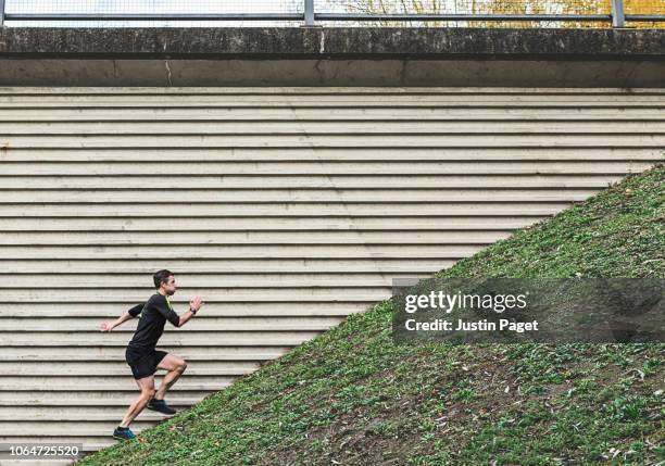 man running up steep hill - steep stock pictures, royalty-free photos & images