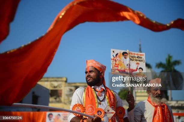 Shiv Sena activists wave a flag at Lakshman Qila during an event for the construction of Ram temple in Ayodhya on November 24, 2018.