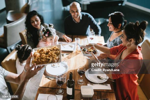 indian friends and family share traditional meal together - indian family dinner table stock pictures, royalty-free photos & images