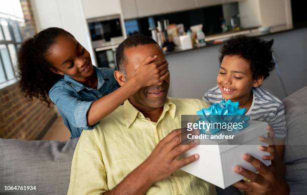 kids surprising their father with a gift for father's day - fathers day stock pictures, royalty-free photos & images