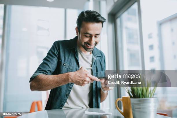 adult man depositing check with smartphone - portable information device stock pictures, royalty-free photos & images