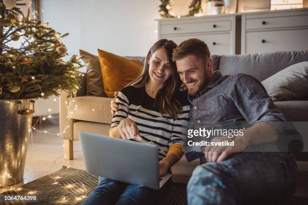 paar thuis voor kerstmis - christmas couple stockfoto's en -beelden