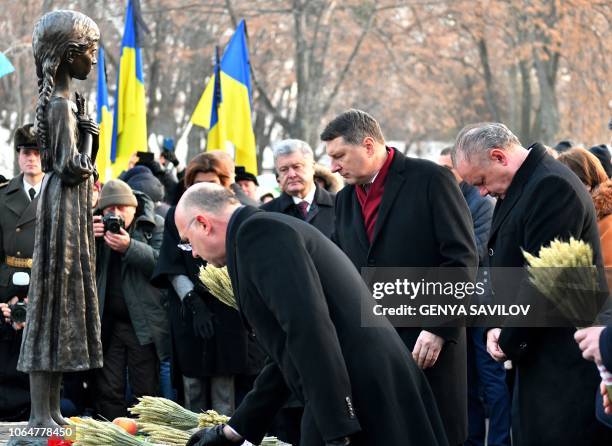 Slovak President Andrej Kiska and Latvia's President Raimonds Vejonis place symbolic sheaves of wheat during a commemoration ceremony at a monument...