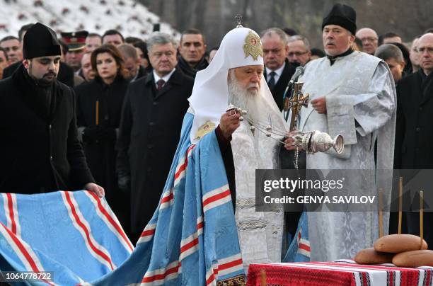 Patriarch Filaret of the Ukrainian Orthodox Church of Kiev's Patriarchate conducts a prayer during a commemoration ceremony at a monument to victims...