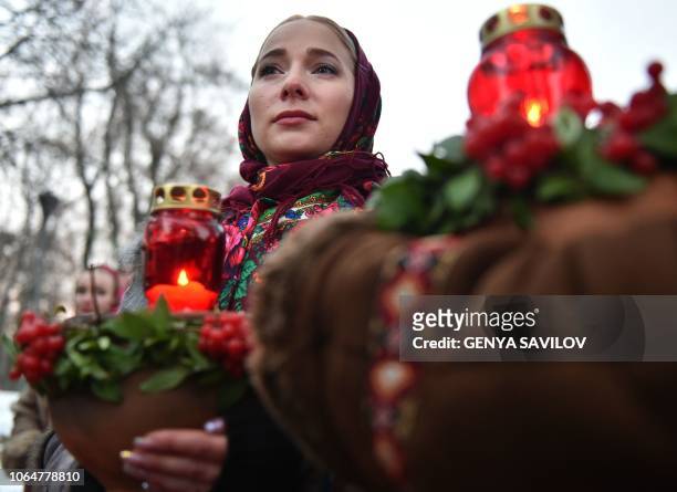 Woman holds a symbolic bowl of wheat and candles during a commemoration ceremony at a monument to victims of the Holodomor famine of 1932-33 in Kiev...