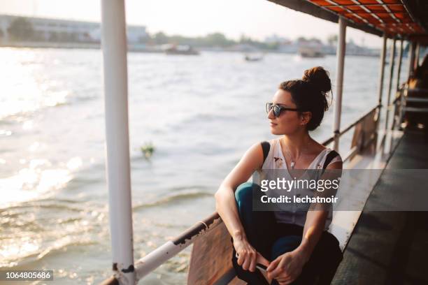 jonge toeristische vrouw rijden op de veerboot van bangkok - boat river stockfoto's en -beelden