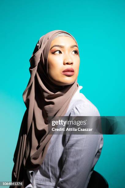 studio portrait of young woman looking up wearing hijab - wedding veil photos et images de collection