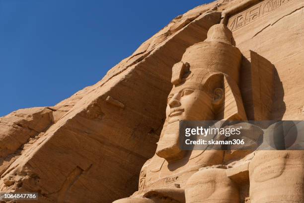 beautiful ruins seated statues of ramesses ii at the great temple of abu simbel. - aswan fotografías e imágenes de stock