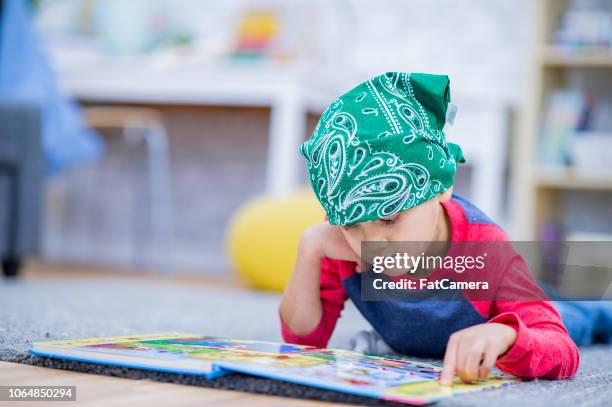 paciente joven enfermo lee libro del cuadro - hospital infantil fotografías e imágenes de stock