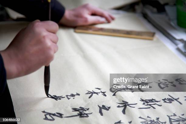 writing chinese calligraphy - chinese calligraphy stock pictures, royalty-free photos & images