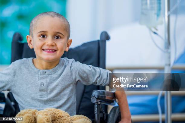 small boy with cancer in wheelchair - childhood cancer stock pictures, royalty-free photos & images