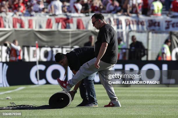 Workers roll up cables and wrap carpets at the Monumental stadium in Buenos Aires, on November 24, 2018 while authorities decide if the second leg...