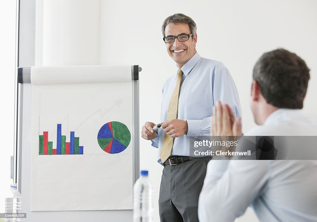 Businessmen with bar graph on Whiteboard, Flipchart at conference room