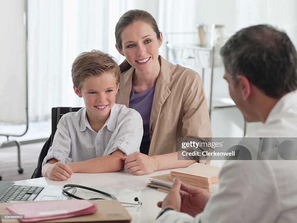 Reife Arzt im Gespräch mit Mutter und Sohn (10-11) in Klinik