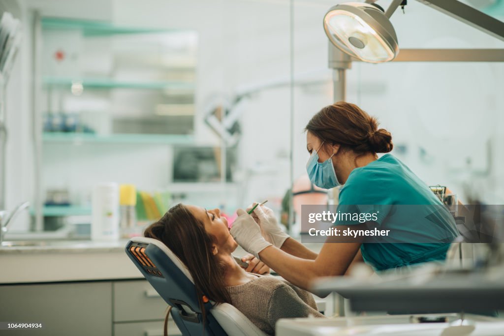 Young woman having her teeth checked during appointment at dentist's office.