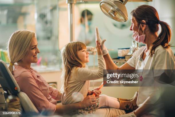 gib mir high-five, du warst toll an zahnärztliche untersuchung! - kinderzahnheilkunde stock-fotos und bilder