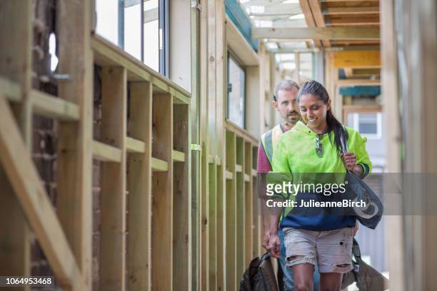 australian construction workers arriving in morning to work with their bags talking in corridor - intern stock pictures, royalty-free photos & images