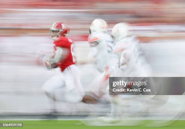 Josh Jacobs of the Alabama Crimson Tide rushes past Deshaun Davis and Noah Igbinoghene of the Auburn Tigers at Bryant-Denny Stadium on November 24,...