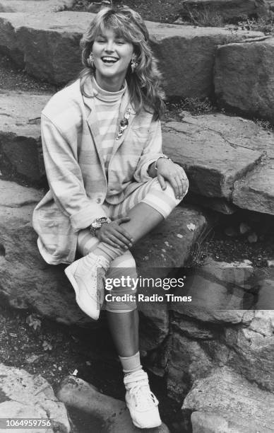 Portrait of television presenter Anthea Turner sitting on stone steps, July 31st 1987.