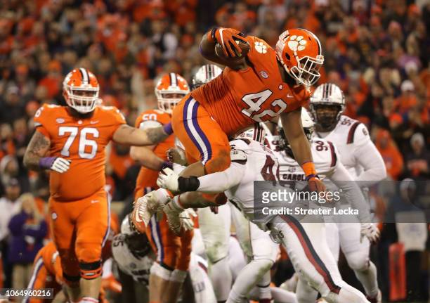 Christian Wilkins of the Clemson Tigers jumps over Sherrod Greene of the South Carolina Gamecocks to score a touchdown during their game at Clemson...