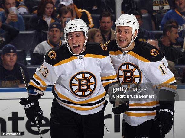 Brad Marchand of the Boston Bruins scores his first NHL goal in the first period against the Buffalo Sabres and is joined by Gregory Campbell at the...