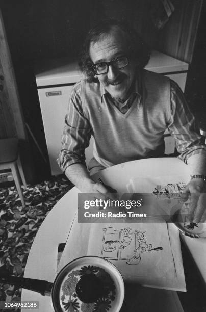 Portrait of cartoonist Bill Tidy with some of his sketches, photographed for Radio Times after designing the trophy for the telvision competition...