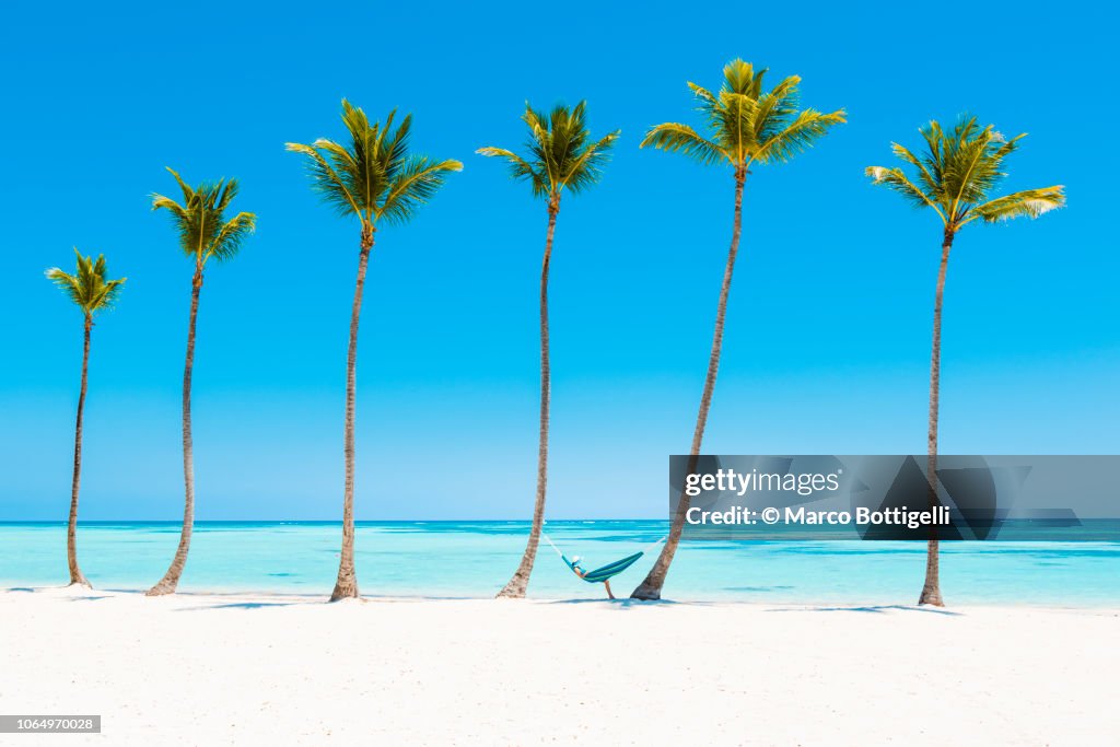 Woman reading on a hammock on a tropical beach