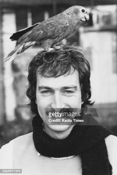 Portrait of BBC Radio 1 disc jockey Steve Wright with an Amazon parrot named 'Jack' perched on his head, circa 1985.