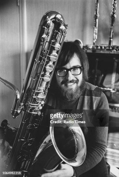 Portrait of musician and composer John Williams with a large brass instrument, circa 1965.