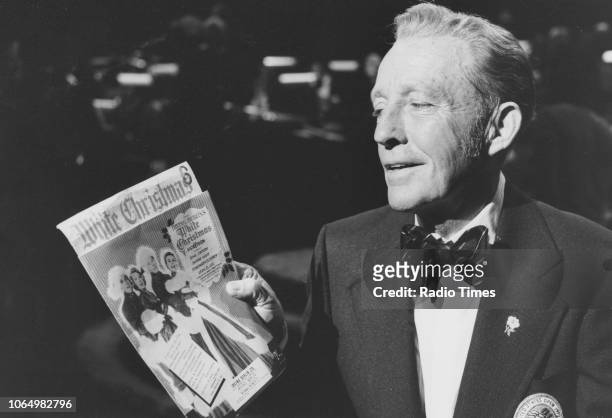 Actor and singer Bing Crosby pictured holding a poster for the film 'White Christmas' on the set of the television chat show 'Parkinson', July 18th...