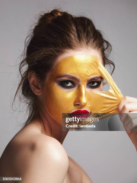 woman with golden peel-off mask - beauty mask stock pictures, royalty-free photos & images