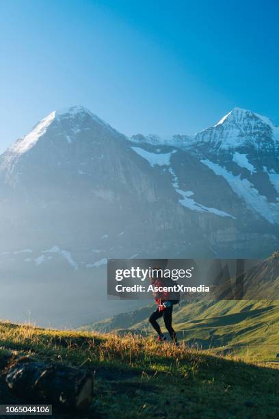 one young female hiker walks up hill - bernese alps stock pictures, royalty-free photos & images
