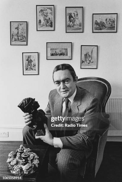 Portrait of television presenter Hugh Scully holding a sculpture, photographed for Radio Times in connection with the BBC show 'Antiques Roadshow',...