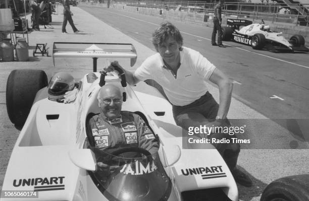 Formula 1 sports commentator Murray Walker at the wheel of a car, watched by F1 driver James Hunt , June 21st 1983.