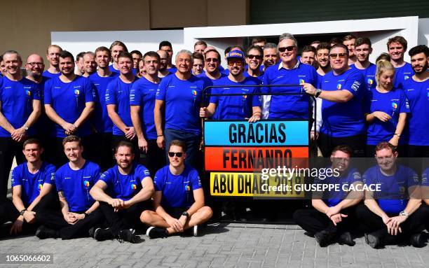 McLaren's Spanish driver Fernando Alonso poses for a photograph with his team ahead of the Abu Dhabi Formula One Grand Prix, his last race for...