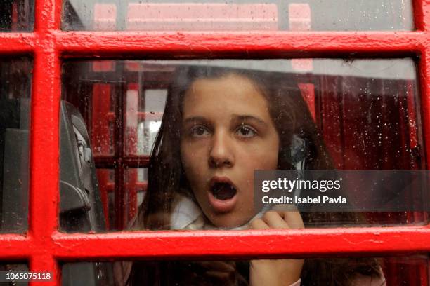 shocked woman receiving news on the phone - pay phone stock pictures, royalty-free photos & images