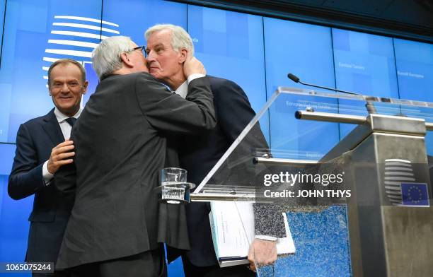 President of the European Commission Jean-Claude Juncker kisses EU chief Brexit negotiator Michel Barnier next to European Council President Donald...
