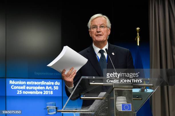 Chief Brexit negotiator Michel Barnier shows the treaty at the end of a press conference following a special meeting of the European Council to...
