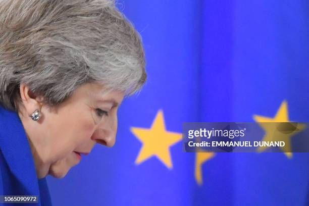 Britain's Prime Minister Theresa May walks past a European Union flag as she arrives to give a press conference following a special meeting of the...