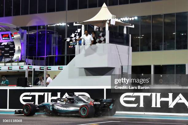 Lewis Hamilton of Great Britain driving the Mercedes AMG Petronas F1 Team Mercedes WO9 takes the chequered flag and the win during the Abu Dhabi...