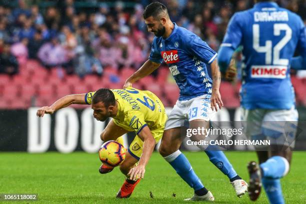 Chievo's Italian forward Riccardo Meggiorini stumbles under pressure from Napoli's Spanish defender Raul Albiol during the Italian Serie A football...