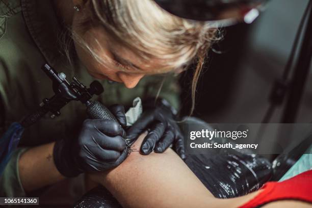 girl tattoo artist - tattoo needle stock pictures, royalty-free photos & images