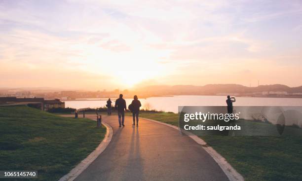 people in the city of gijon at sunset - gijón fotografías e imágenes de stock