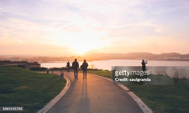 people in the city of gijon at sunset - gijon stock pictures, royalty-free photos & images